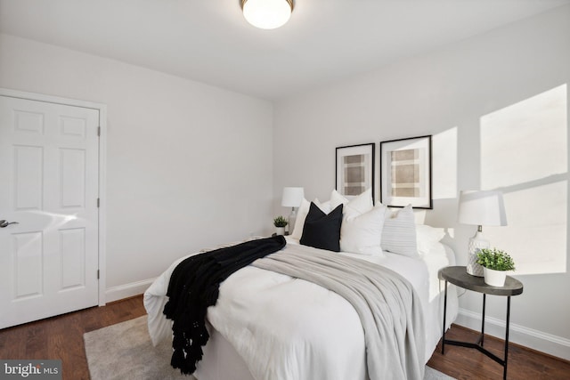 bedroom with baseboards and wood finished floors