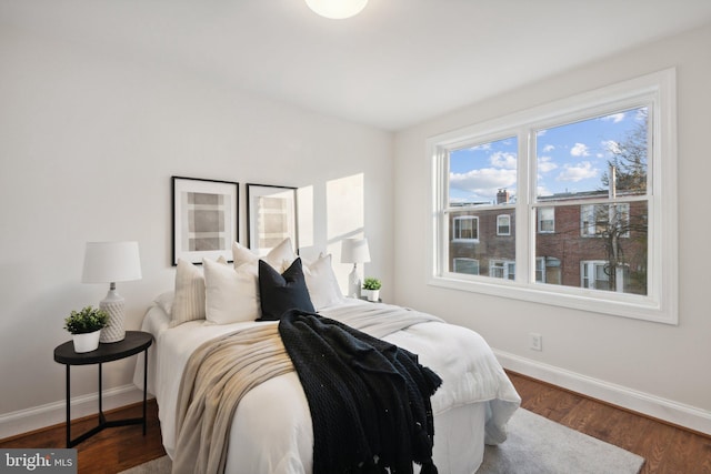 bedroom with baseboards and wood finished floors