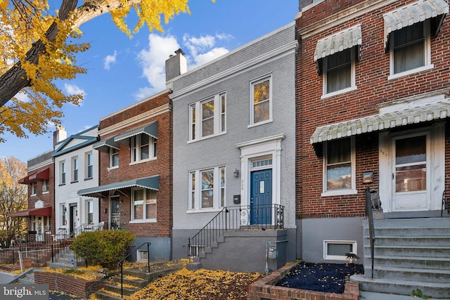 view of property with a chimney and brick siding