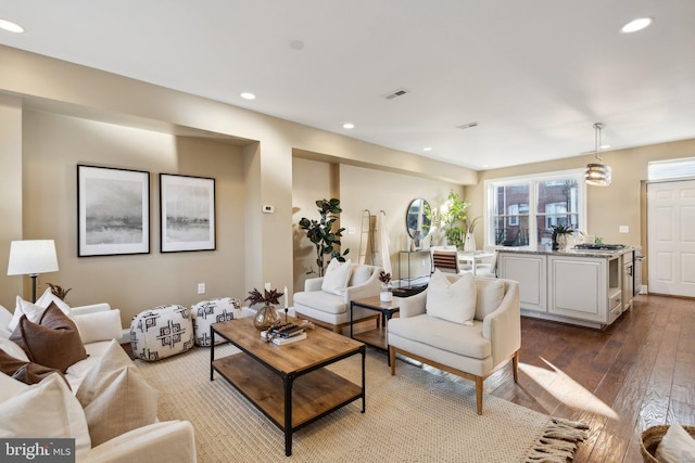 living room featuring recessed lighting, dark wood finished floors, and visible vents