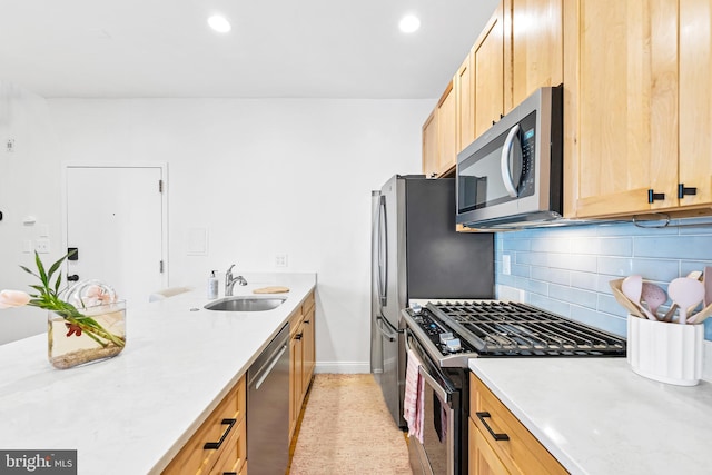 kitchen featuring a sink, light brown cabinets, stainless steel appliances, a peninsula, and backsplash