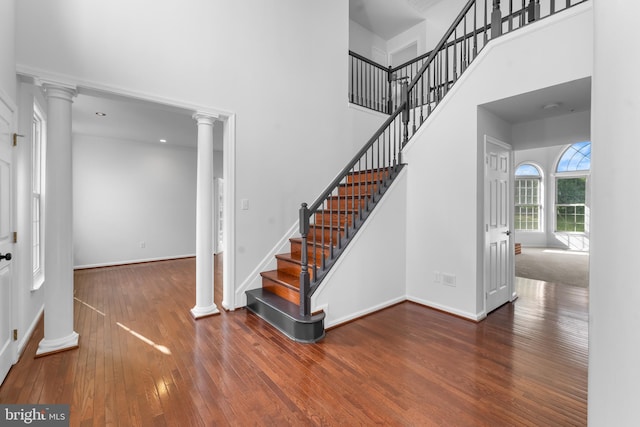 601 James Ridge Rd, Bowie, MD 20721 - stairway with ornate columns, a towering ceiling, wood-type flooring, and baseboards