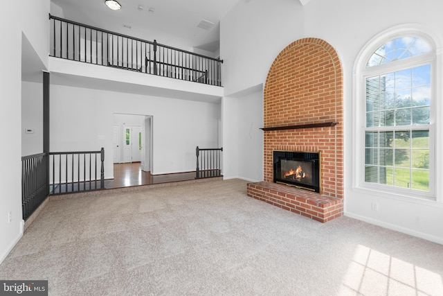 601 James Ridge Rd, Bowie, MD 20721 - unfurnished living room featuring carpet flooring, a towering ceiling, a brick fireplace, and baseboards