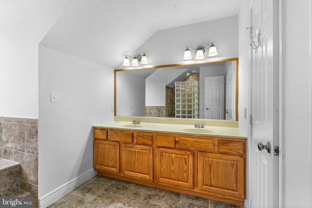 601 James Ridge Rd, Bowie, MD 20721 - bathroom featuring double vanity, vaulted ceiling, baseboards, and tiled shower