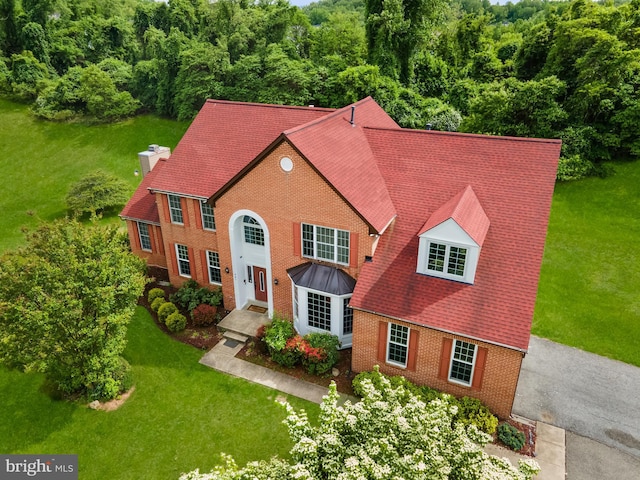 601 James Ridge Rd, Bowie, MD 20721 - view of front facade featuring brick siding, a chimney, a front yard, and a view of trees