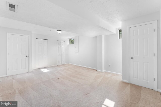 601 James Ridge Rd, Bowie, MD 20721 - unfurnished bedroom with two closets, light colored carpet, a textured ceiling, baseboards, and multiple windows