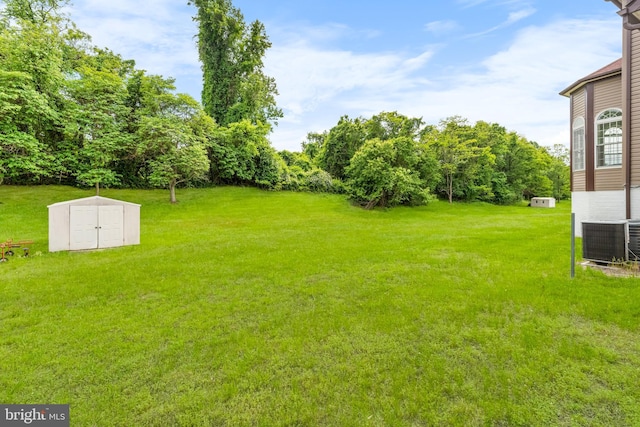 601 James Ridge Rd, Bowie, MD 20721 - view of grassy yard featuring central air condition unit, a storage shed, and an outdoor structure