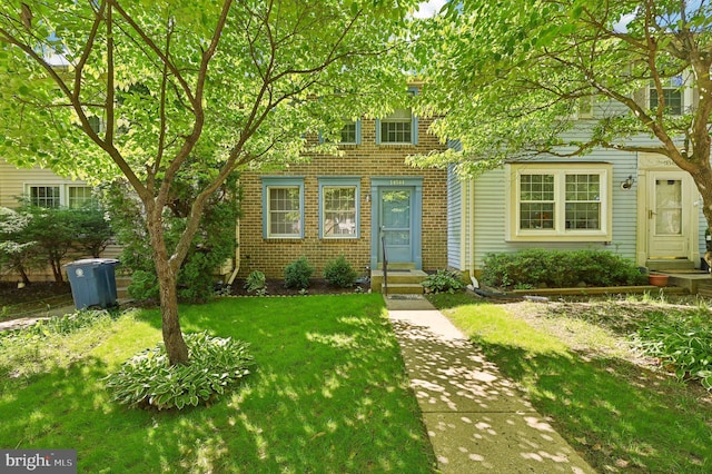 view of front facade featuring a front lawn and brick siding