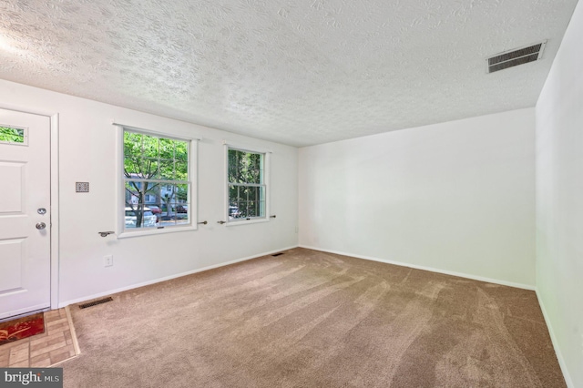entrance foyer with carpet flooring, a textured ceiling, and baseboards