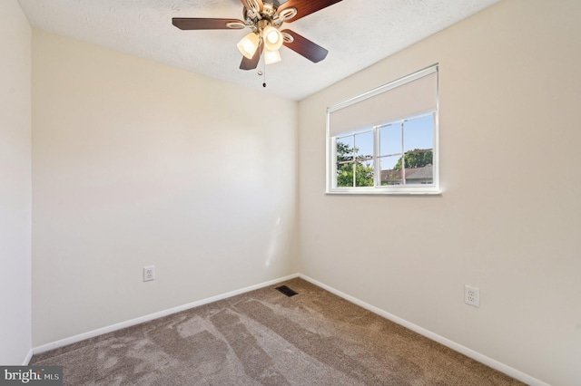 carpeted spare room featuring baseboards and a ceiling fan