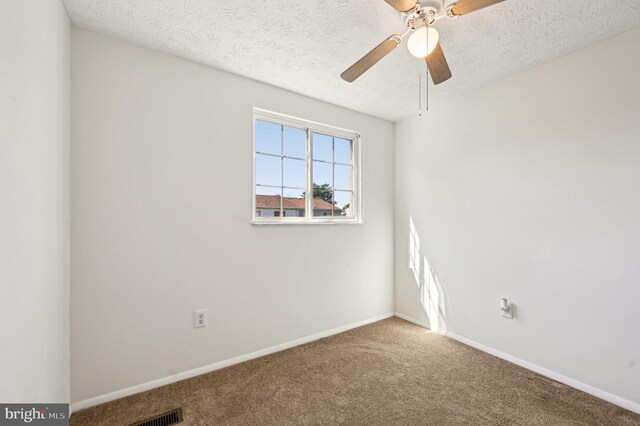 unfurnished room with carpet flooring, ceiling fan, a textured ceiling, and baseboards