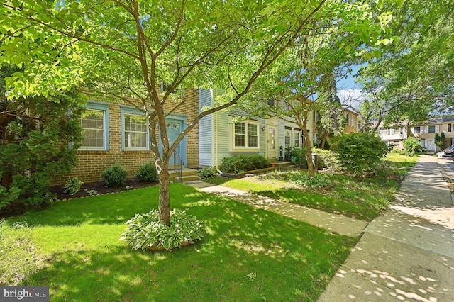 view of front of home featuring a front lawn, brick siding, and entry steps