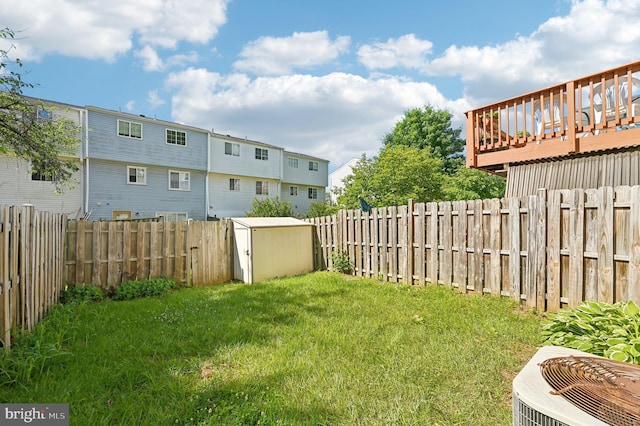 view of yard with central AC, a wooden deck, and a residential view