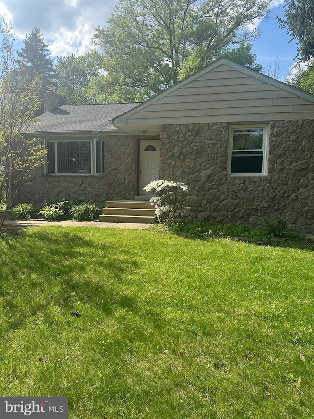 view of front facade with stone siding, a chimney, and a front yard