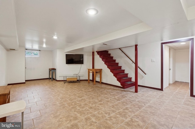 basement featuring baseboards, stairway, and recessed lighting