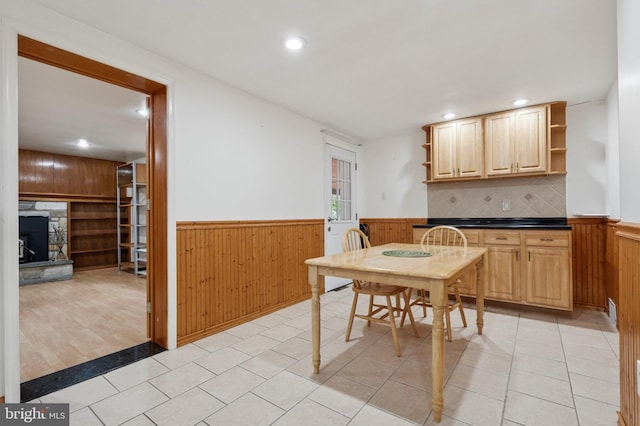 dining space with wooden walls, a fireplace, wainscoting, and recessed lighting
