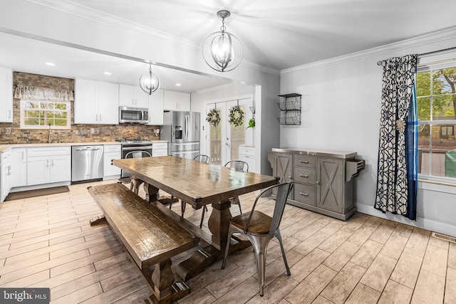 dining space featuring light wood-type flooring, crown molding, baseboards, and recessed lighting