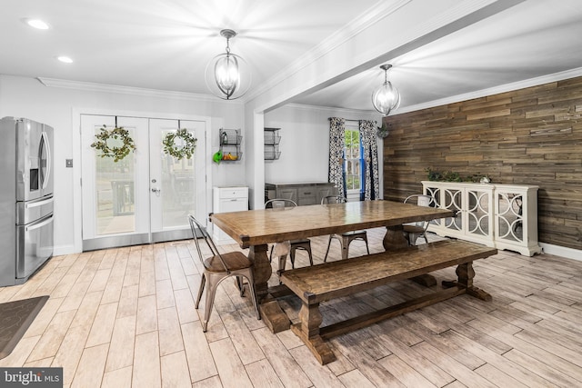 dining space featuring french doors, light wood-type flooring, a chandelier, crown molding, and baseboards