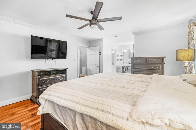 bedroom with wood finished floors, ornamental molding, baseboards, a ceiling fan, and connected bathroom
