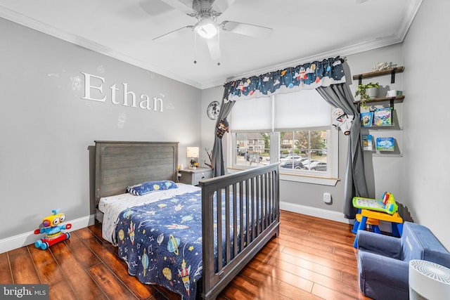 bedroom featuring crown molding, baseboards, wood-type flooring, and ceiling fan