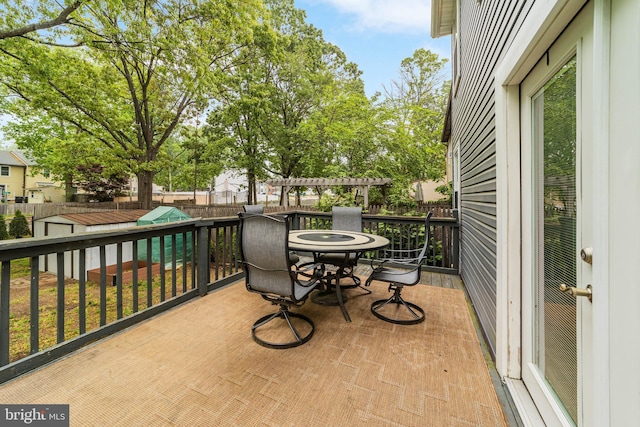 wooden terrace with a fenced backyard and outdoor dining area