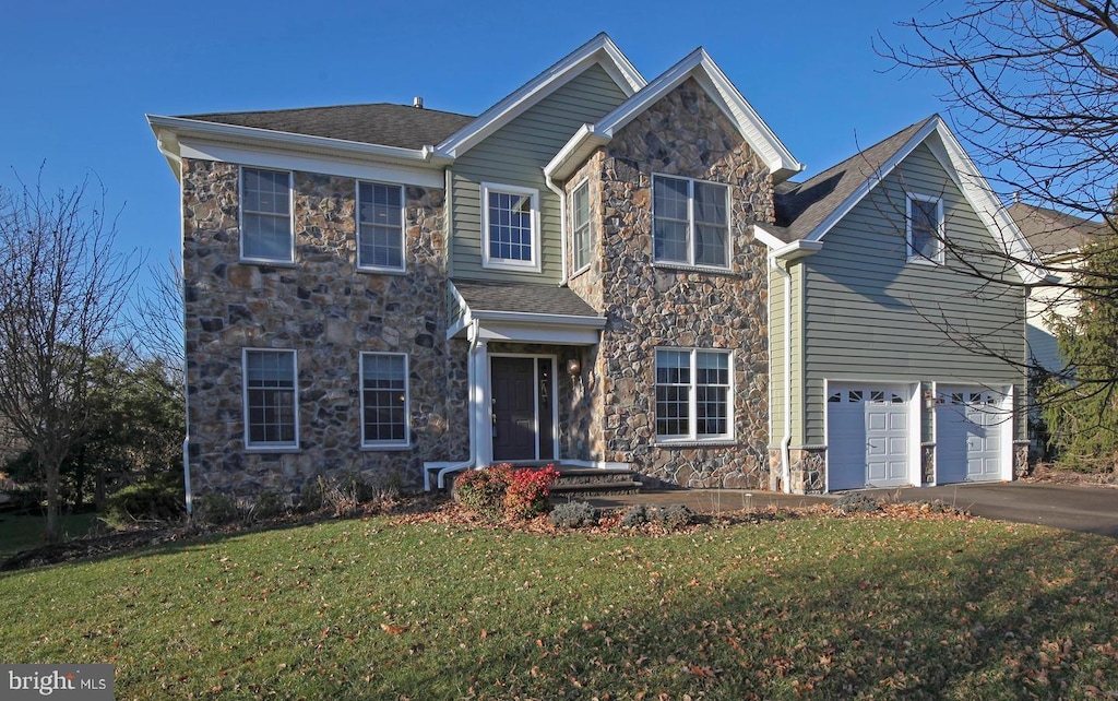 traditional-style home with stone siding, asphalt driveway, a front lawn, and an attached garage