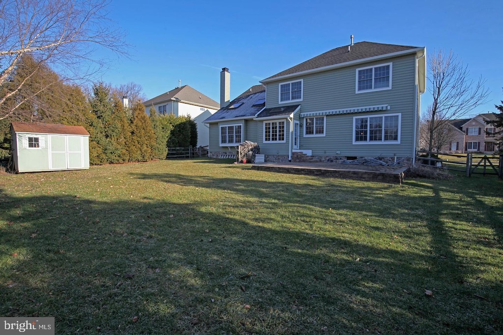 rear view of house featuring a storage unit, an outdoor structure, and a chimney