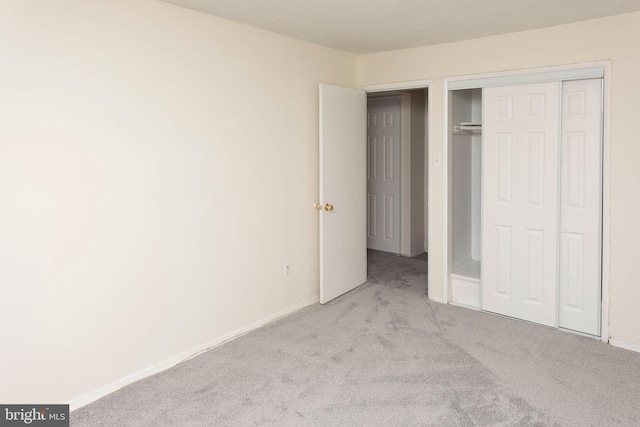unfurnished bedroom featuring a closet, carpet flooring, and baseboards