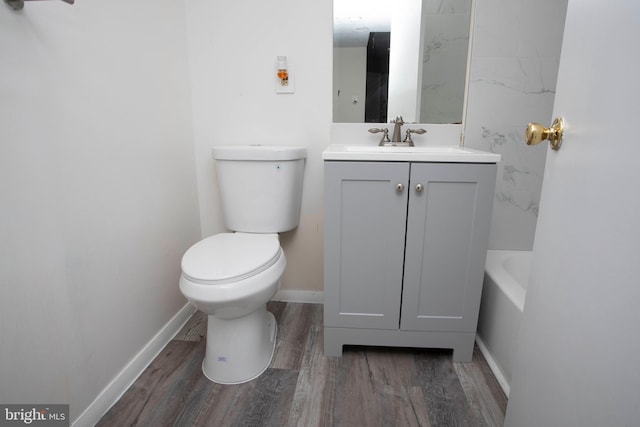 bathroom featuring vanity, baseboards, toilet, and wood finished floors