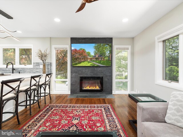 living room with wood finished floors, recessed lighting, healthy amount of natural light, a fireplace, and a ceiling fan