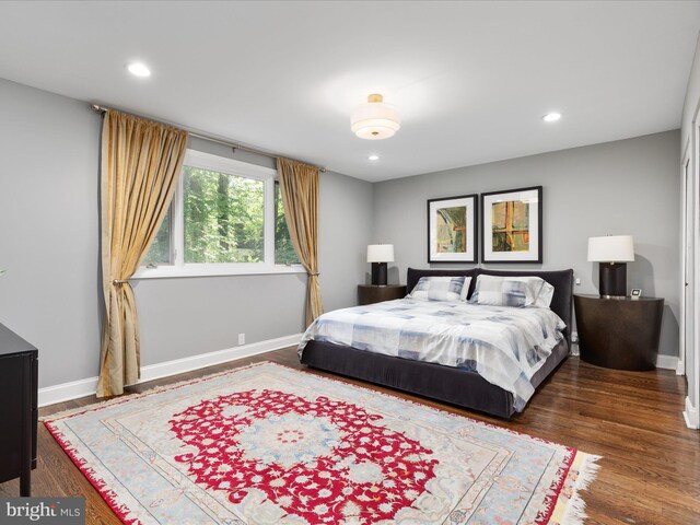 bedroom featuring baseboards, wood finished floors, and recessed lighting