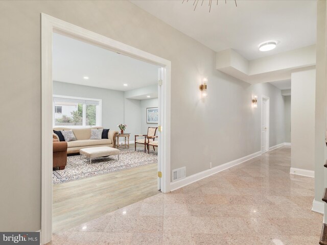 corridor featuring granite floors, baseboards, and recessed lighting