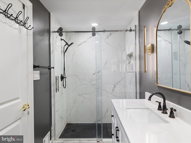 bathroom featuring a marble finish shower and vanity