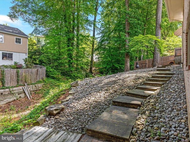 view of yard with fence and stairs