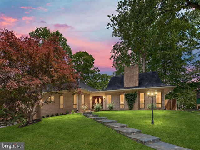 view of front of property featuring a chimney and brick siding