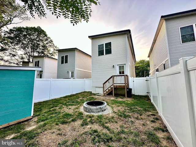 304 1st St, Colonial Beach, VA 22443 - rear view of house featuring a fenced backyard, a fire pit, and an outbuilding