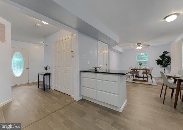 411 N Ln, Prince Frederick, MD 20678 - kitchen featuring ceiling fan, dark countertops, light wood-style flooring, and white cabinets