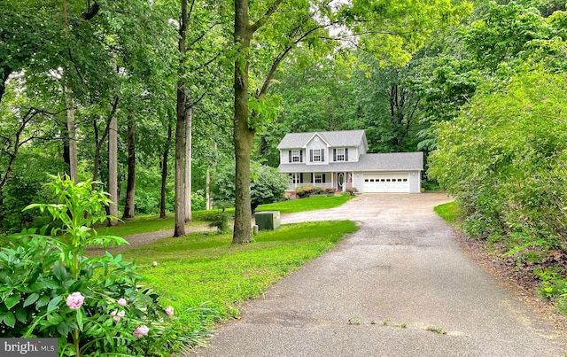 411 N Ln, Prince Frederick, MD 20678 - view of front of home with asphalt driveway, an attached garage, a front lawn, and a forest view