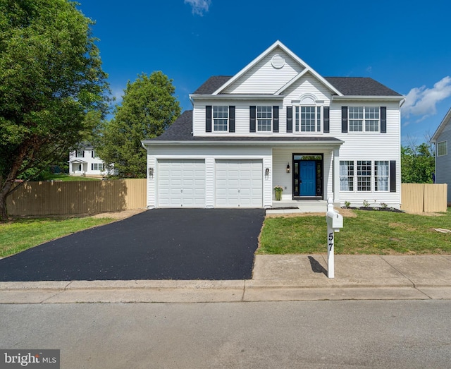 traditional home with driveway, a shingled roof, and a garage
