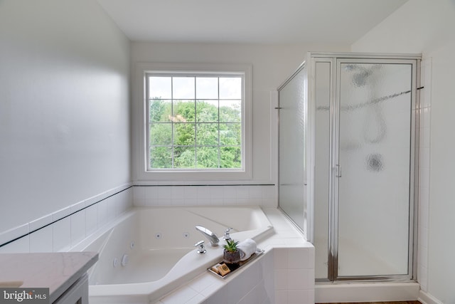 bathroom featuring a shower stall, a jetted tub, and vanity