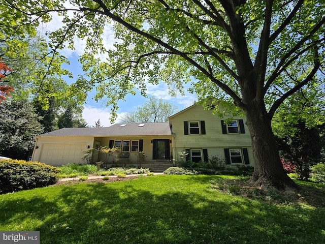 split level home featuring an attached garage and a front lawn