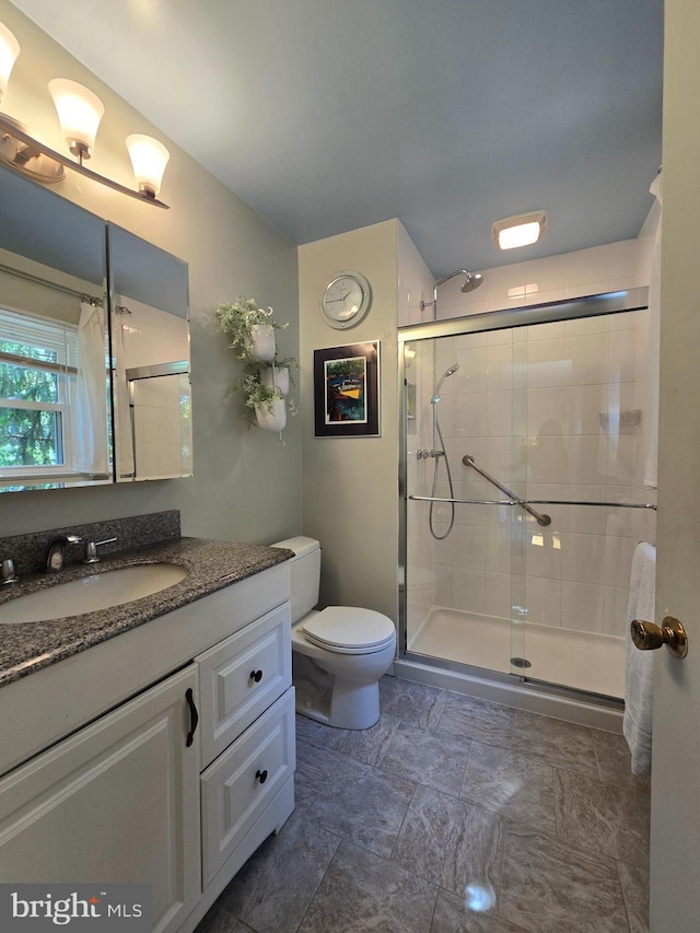 full bath featuring toilet, a shower stall, and vanity