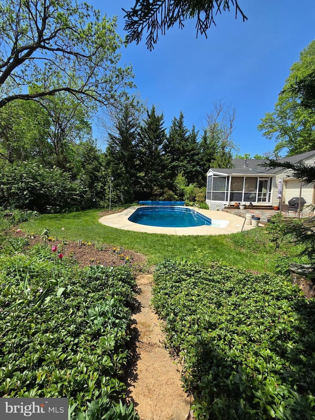 pool with a lawn, a sunroom, and a patio area
