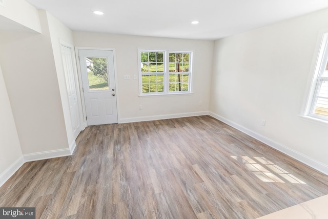 foyer entrance with a wealth of natural light, wood finished floors, and baseboards