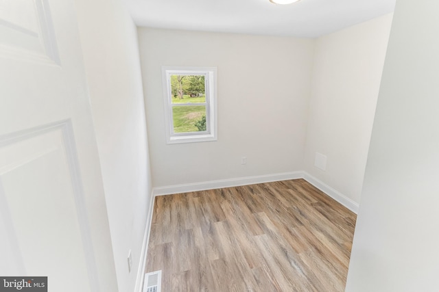 unfurnished room featuring visible vents, wood finished floors, and baseboards