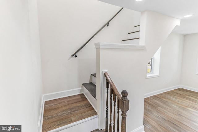 stairway with baseboards and wood finished floors