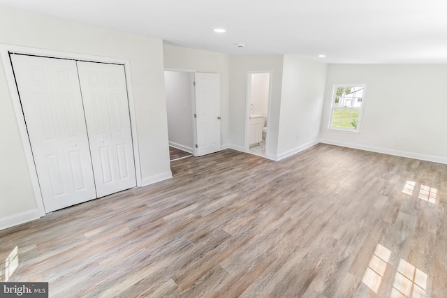 unfurnished bedroom with baseboards, a closet, light wood-style flooring, and recessed lighting