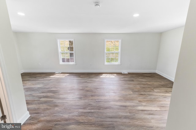 spare room with plenty of natural light, baseboards, and wood finished floors