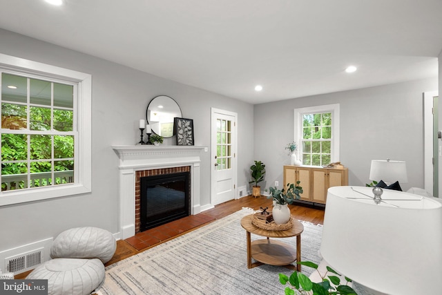 living room with a fireplace, recessed lighting, wood finished floors, and baseboards