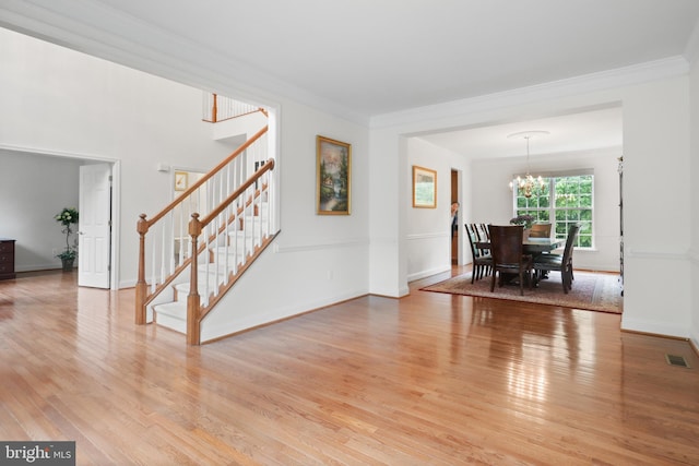 11404 Ramsburg Ct, North Potomac, MD 20878 - dining area with stairs, a chandelier, light wood-style floors, ornamental molding, and baseboards